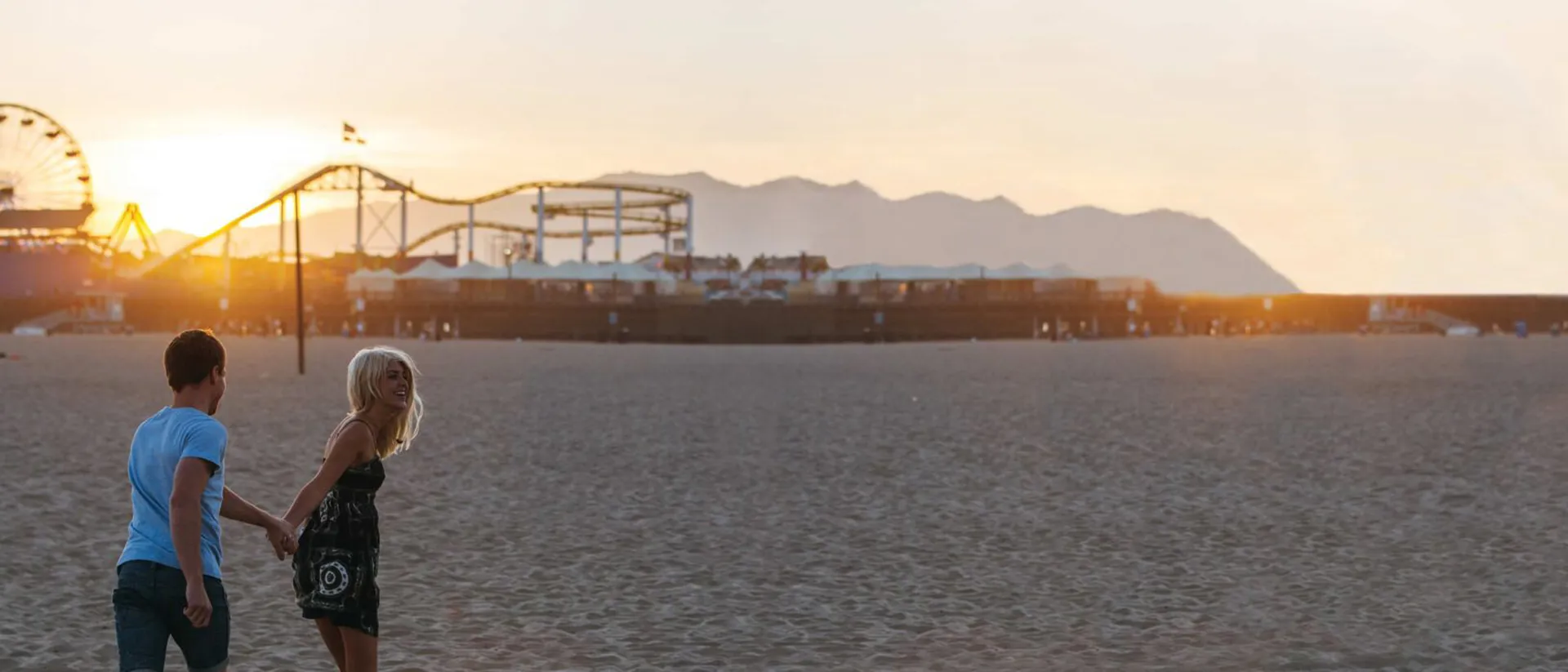 Couple holding hands on Santa Monica Beach at sunset, California, USA Couple holding hands on Santa Monica Beach at sunset, California, USA
