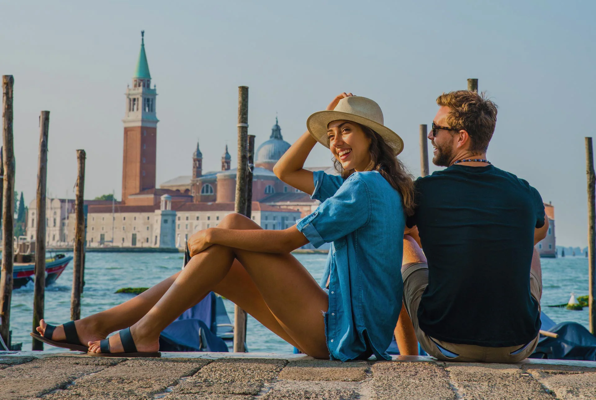 Man and a woman sitting on a dock in Venice