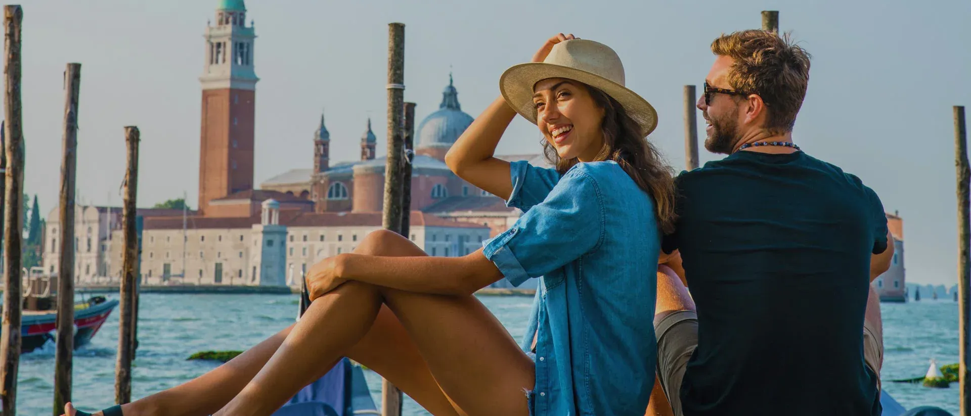 Man and a woman sitting on a dock in Venice
