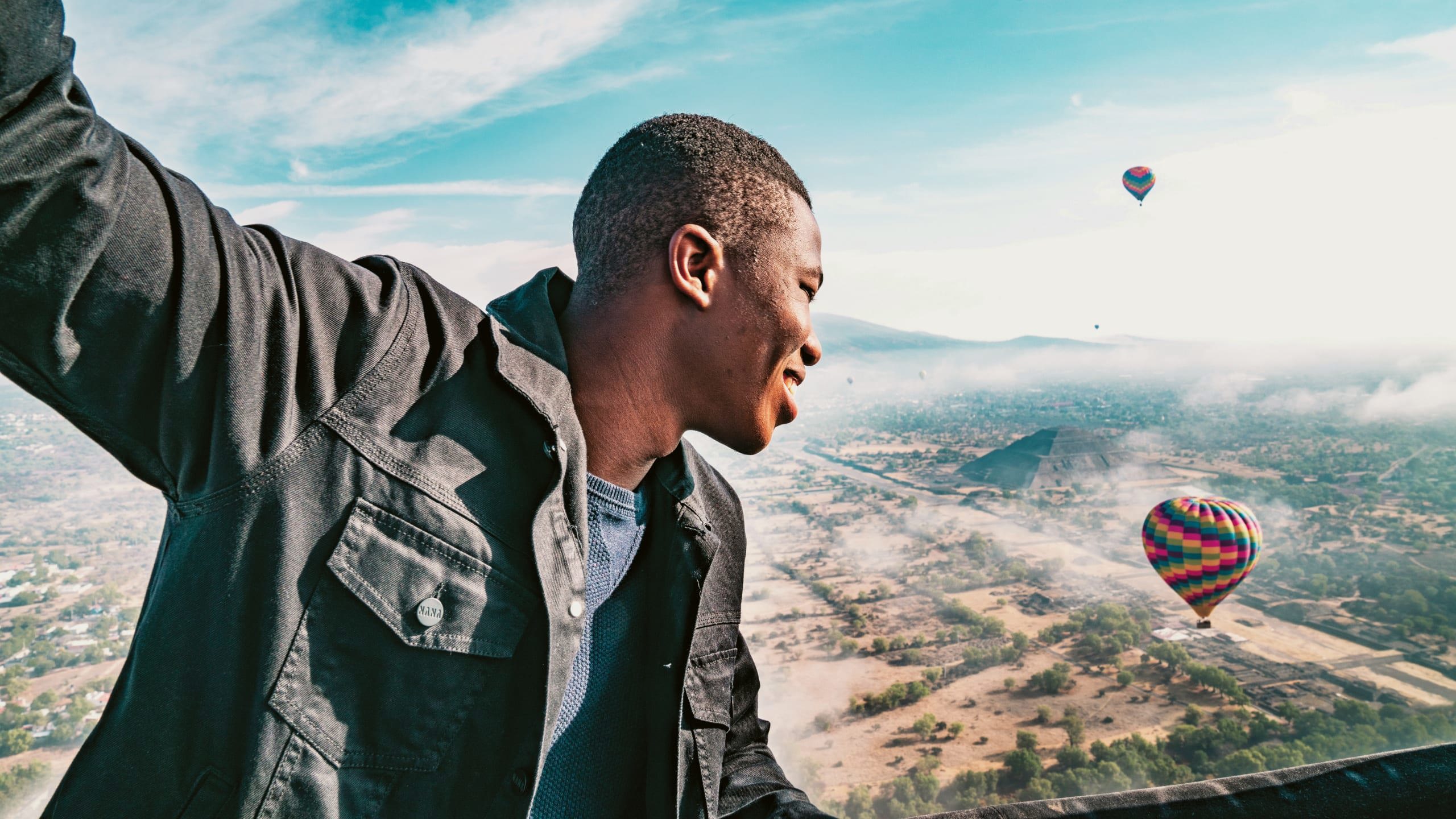 A man enjoying a hot air balloon flight over the Pyramids of Teotihuacán on Contiki's Mexican Fiesta Tour