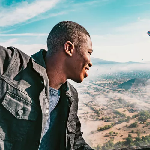 A man enjoying a hot air balloon flight over the Pyramids of Teotihuacán on Contiki's Mexican Fiesta Tour