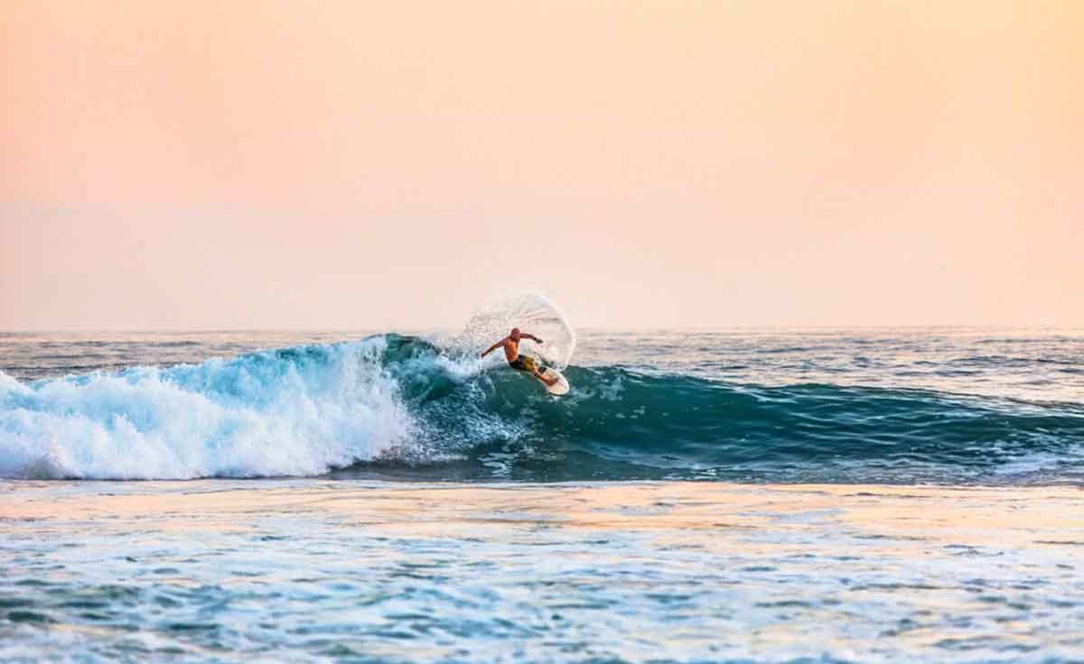 Surfer riding a wave at sunset