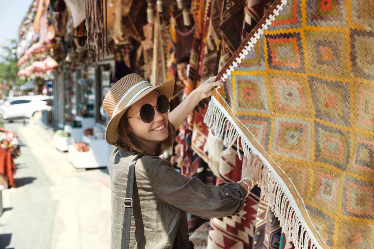 Smiling Young Woman Buying Shawl At Market Stall In Goreme Cappadocia Turkey