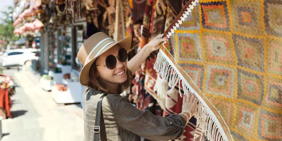 Smiling Young Woman Buying Shawl At Market Stall In Goreme Cappadocia Turkey