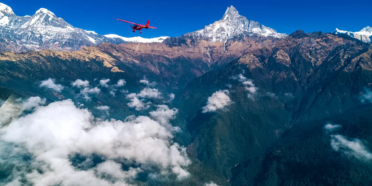 Small Red Place Flying Over High Mountains