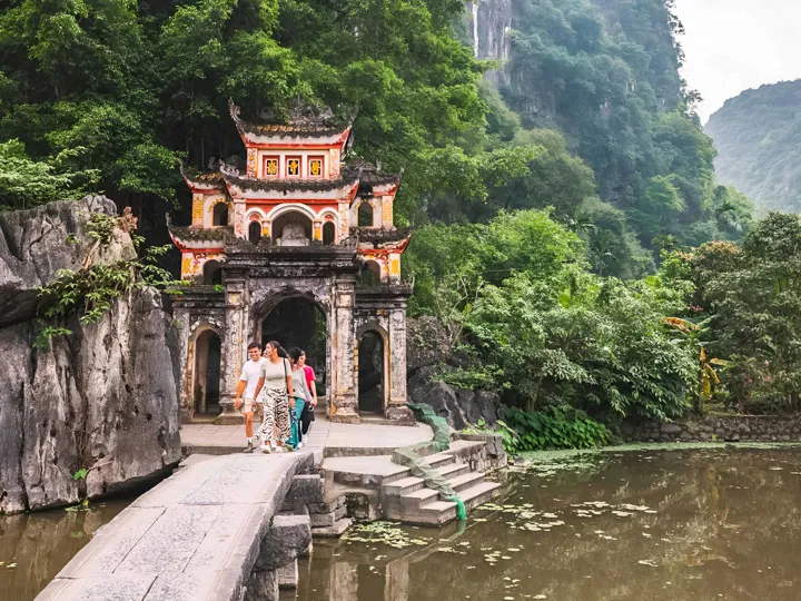 Group Of Young People Walking Close To Temple Gates in Vietnam.