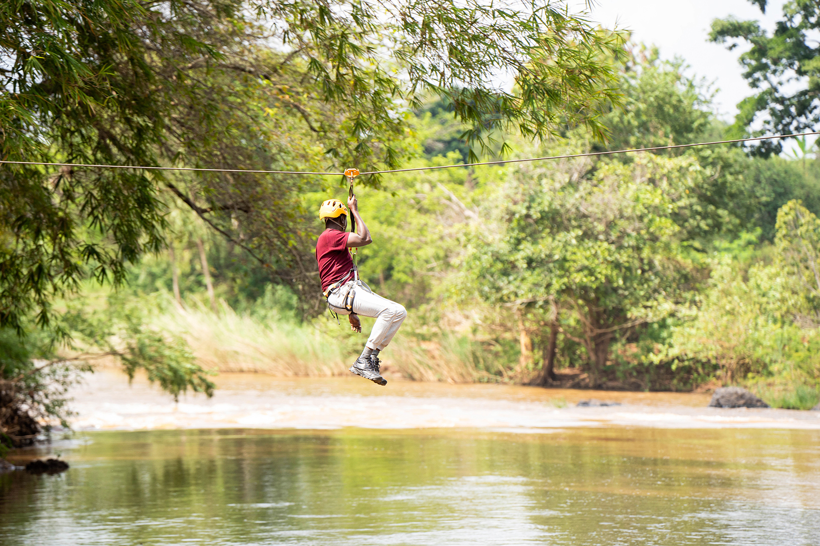 Traveller ziplining over a river in Sagana, Kenya