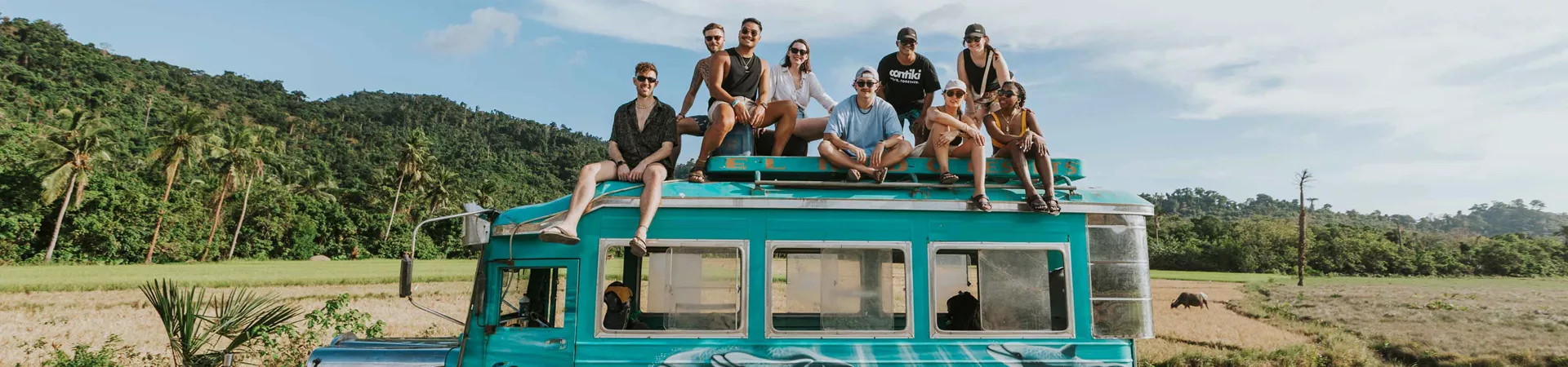 Group Of Young Travelers Sitting On Top Of Cool Bus Philippines