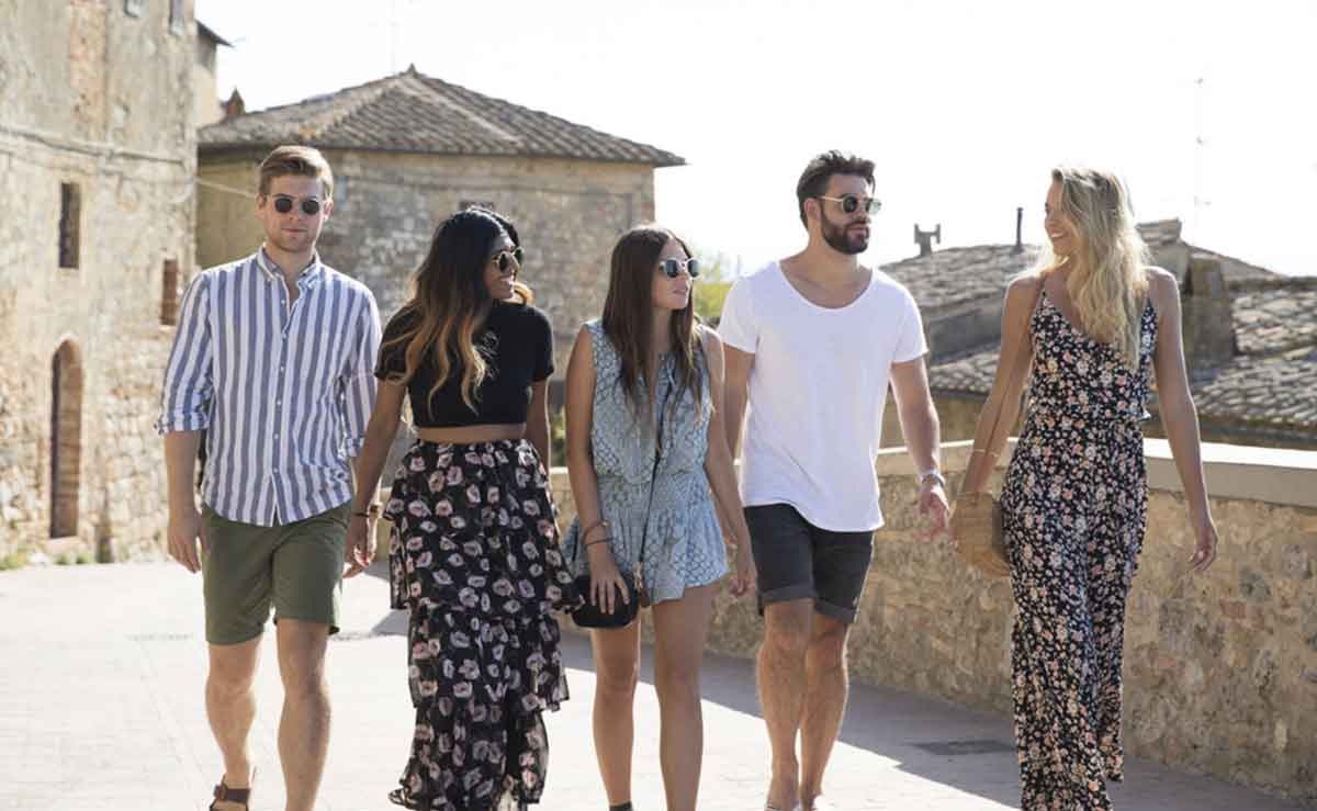 Group Of Young Travelers Walking In The Sun