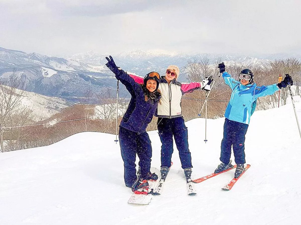Three friends skiing in the snow.