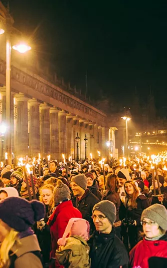 Contiki travellers joining the famous Edinburgh Hogmanay Torchlight Procession with thousands of torch-bearing revellers outside the Royal Scottish Academy at night