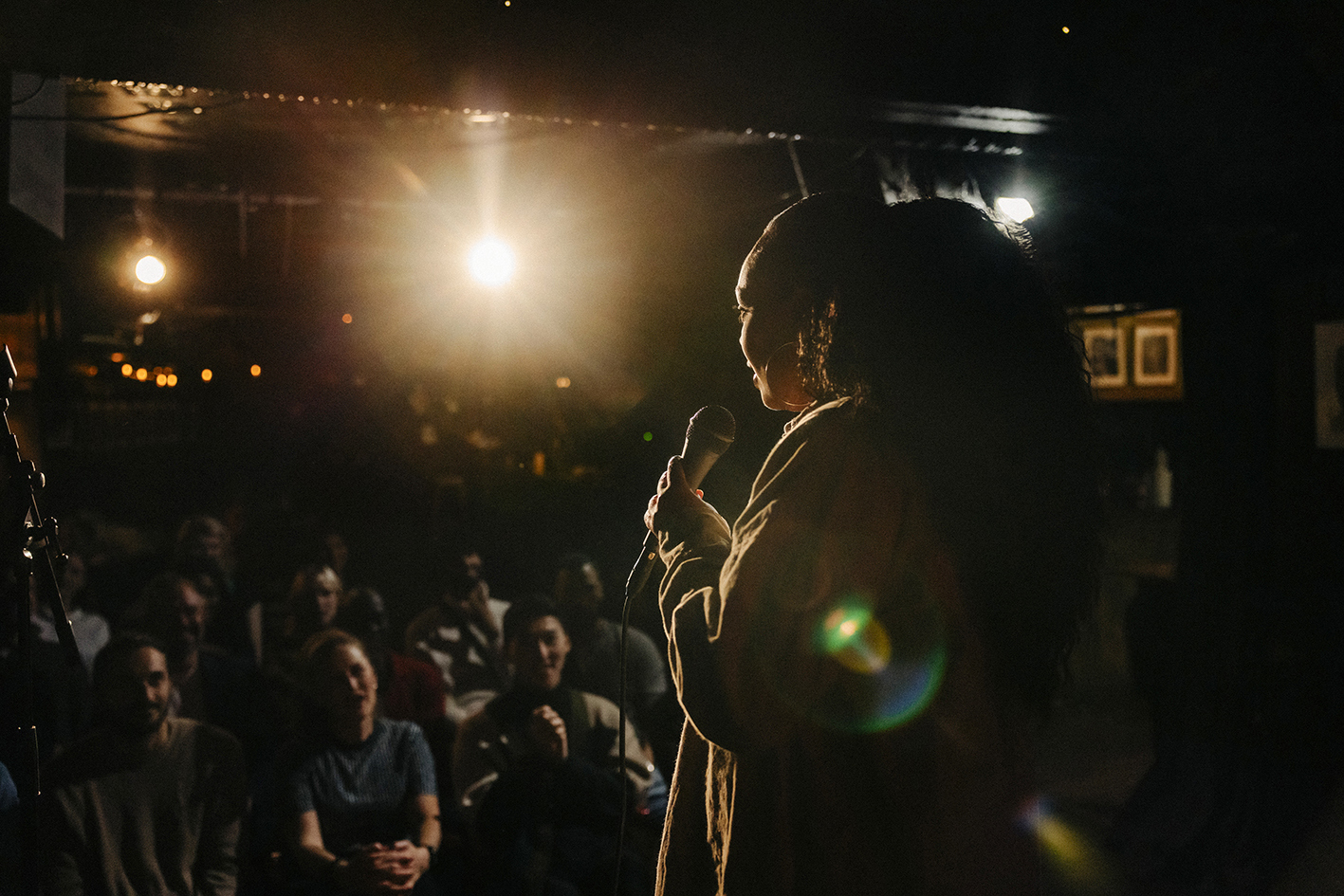 Comedian performing stand-up on stage in front of an audience