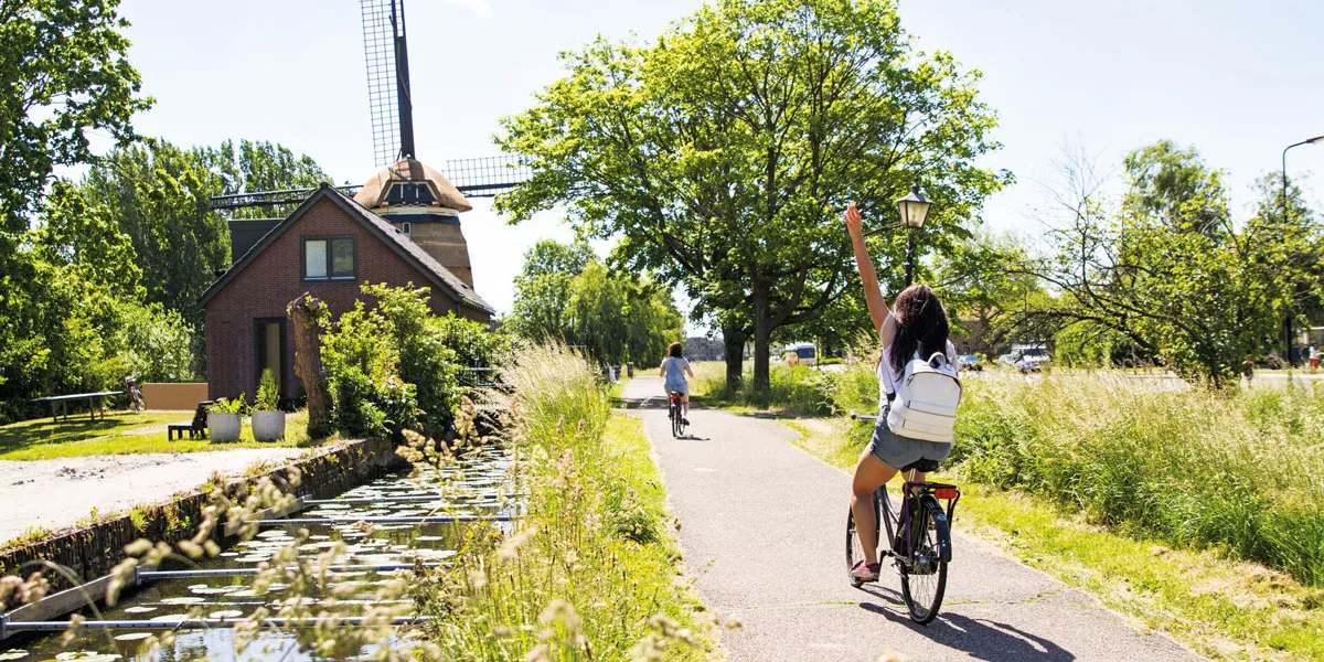 Biking Ride Next To Windmill Sunny Day
