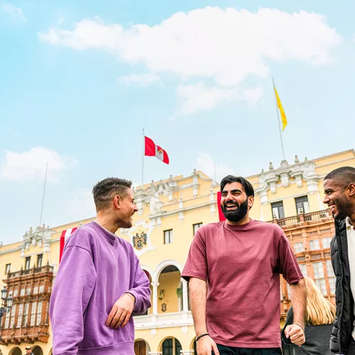 Three travellers chatting standing in Plaza Mayor de Lima, Peru