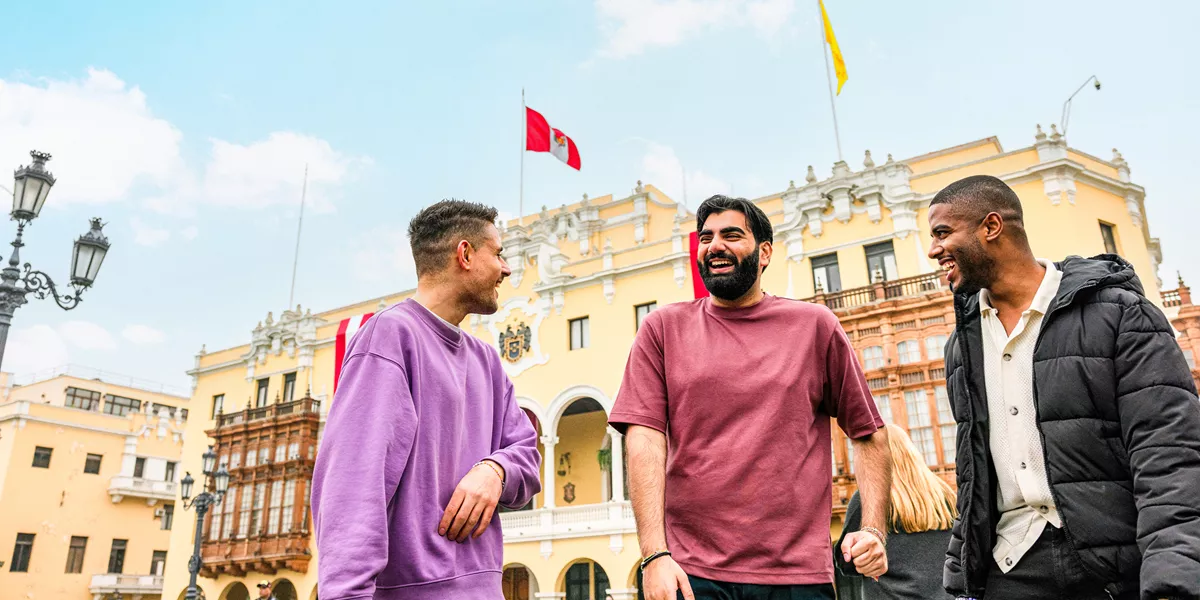 Three travellers chatting standing in Plaza Mayor de Lima, Peru
