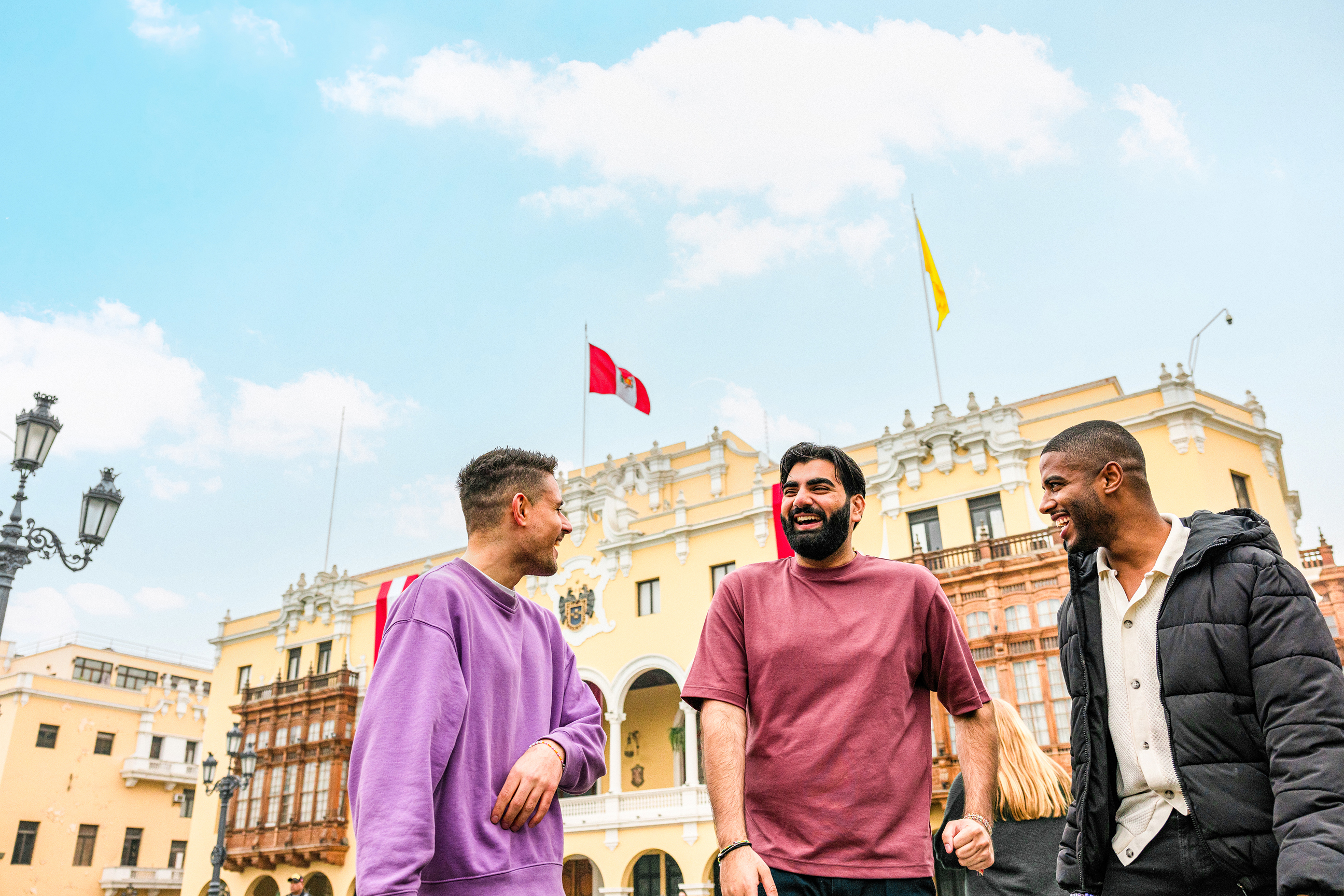 Three travellers chatting standing in Plaza Mayor de Lima, Peru