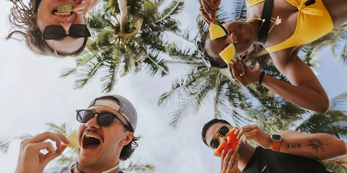 Happy Young People Holding Fruits And Smiling