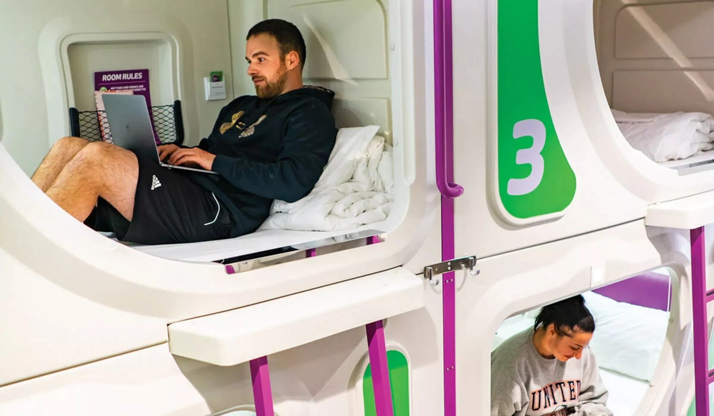 Man and woman in beds in hostel, New Zealand