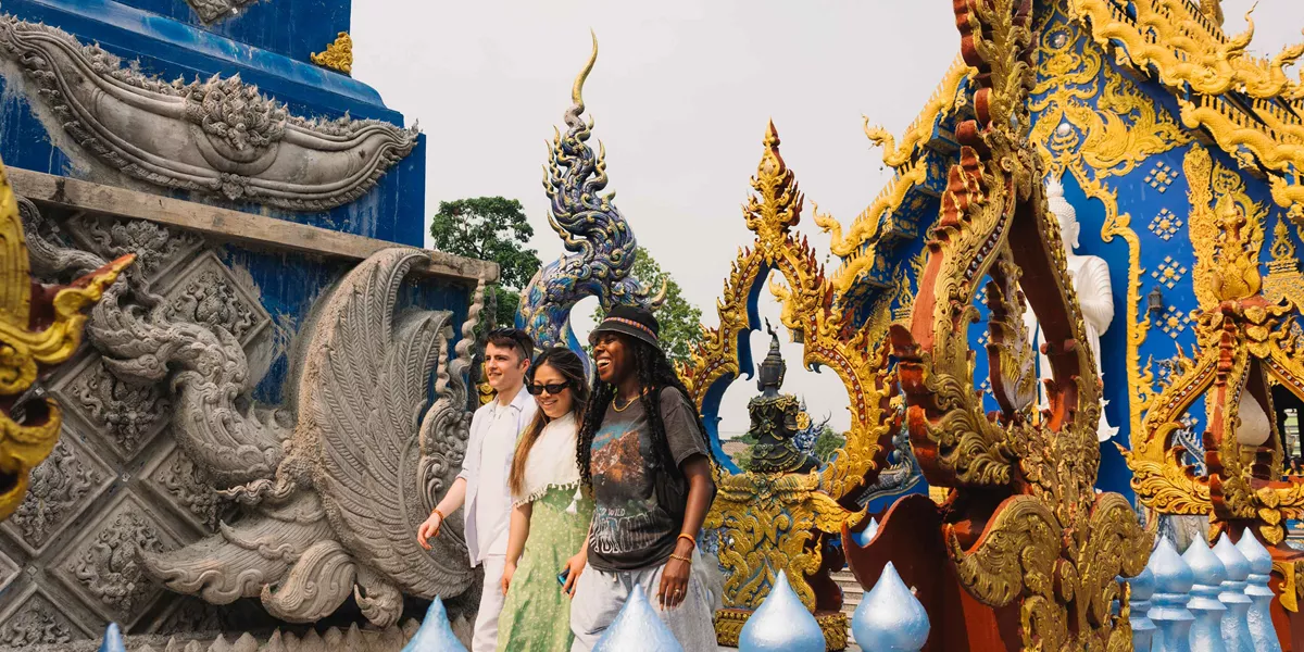 Travellers Walking In Front Of Temples In Thailand