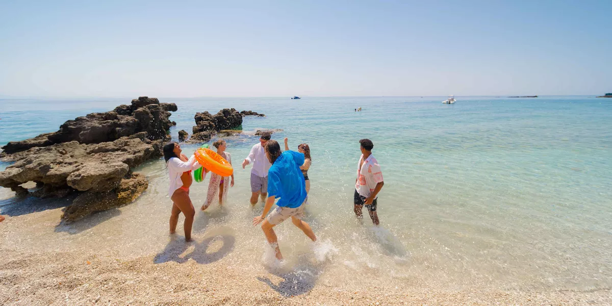 Group Of Young Travelers Enjoying The Beach In The Albanian Sun
