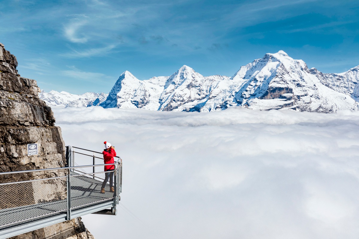 Woman Standing On A High Platform Observing Snowy Mountains in Switzerland.