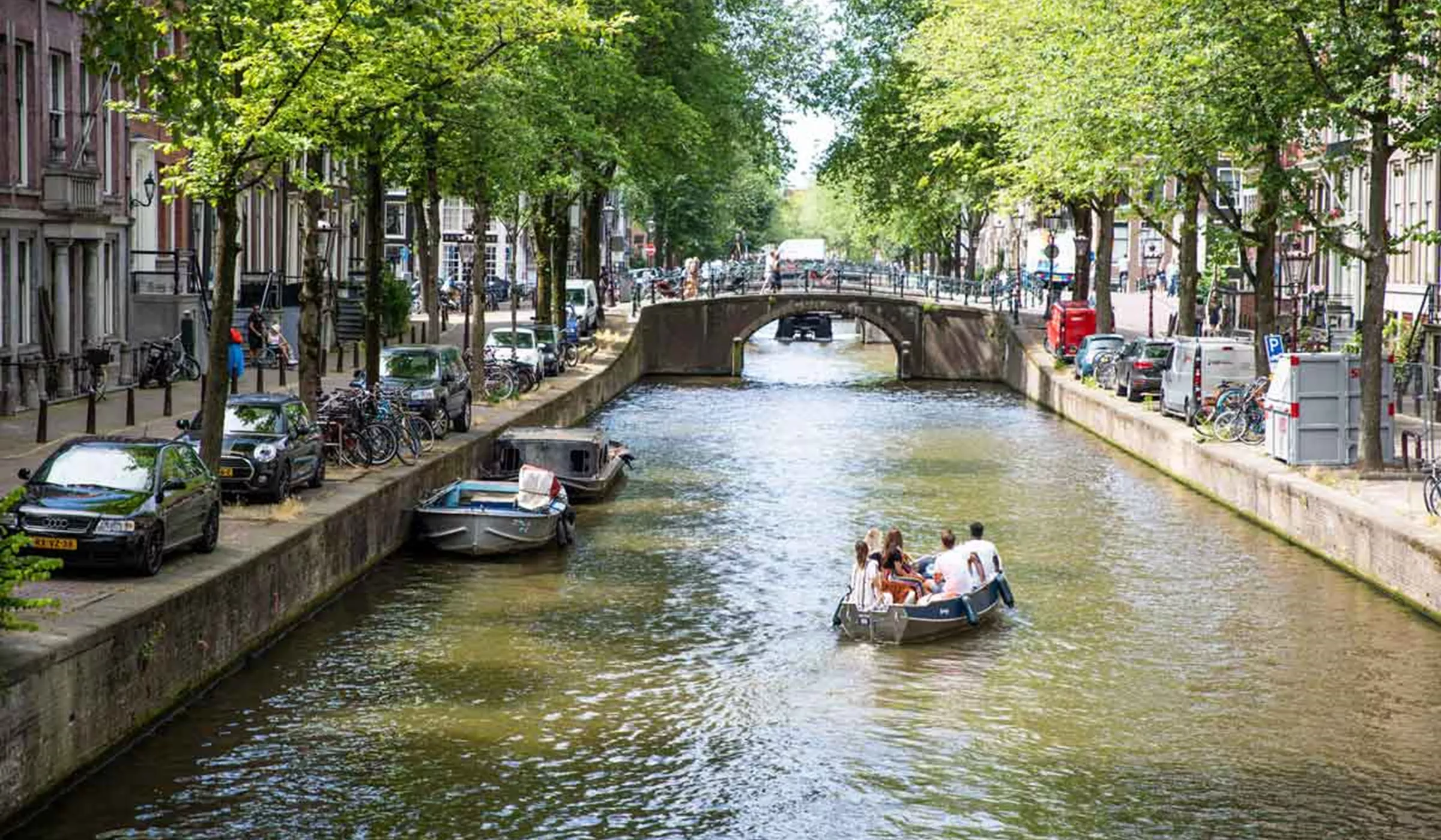 People in boats in city canal on a sunny day