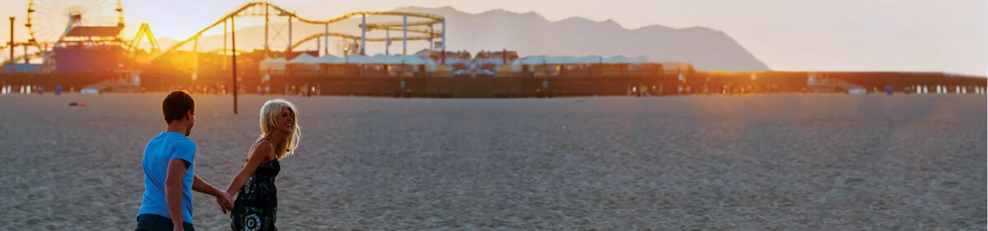 Couple at the beach with festival and mountains in the background