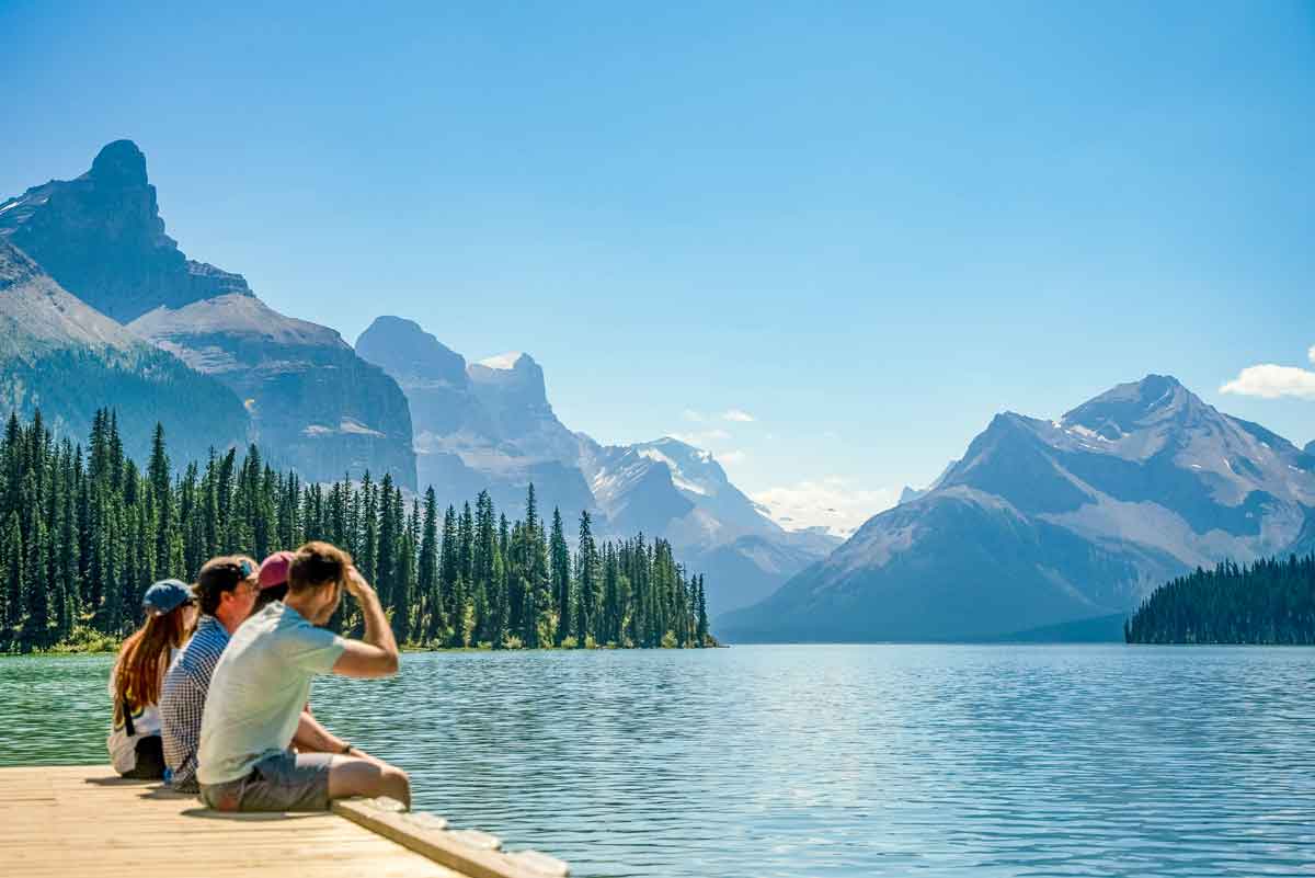 trio-of-travelers-sitting-near-lake-in-canada.jpg