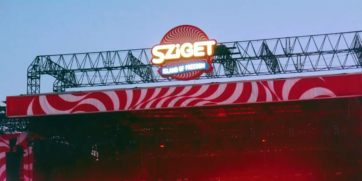 Sziget Festival main stage at dusk in Budapest Hungary with illuminated logo and red swirl stage design - Contiki Europe Festival Tour