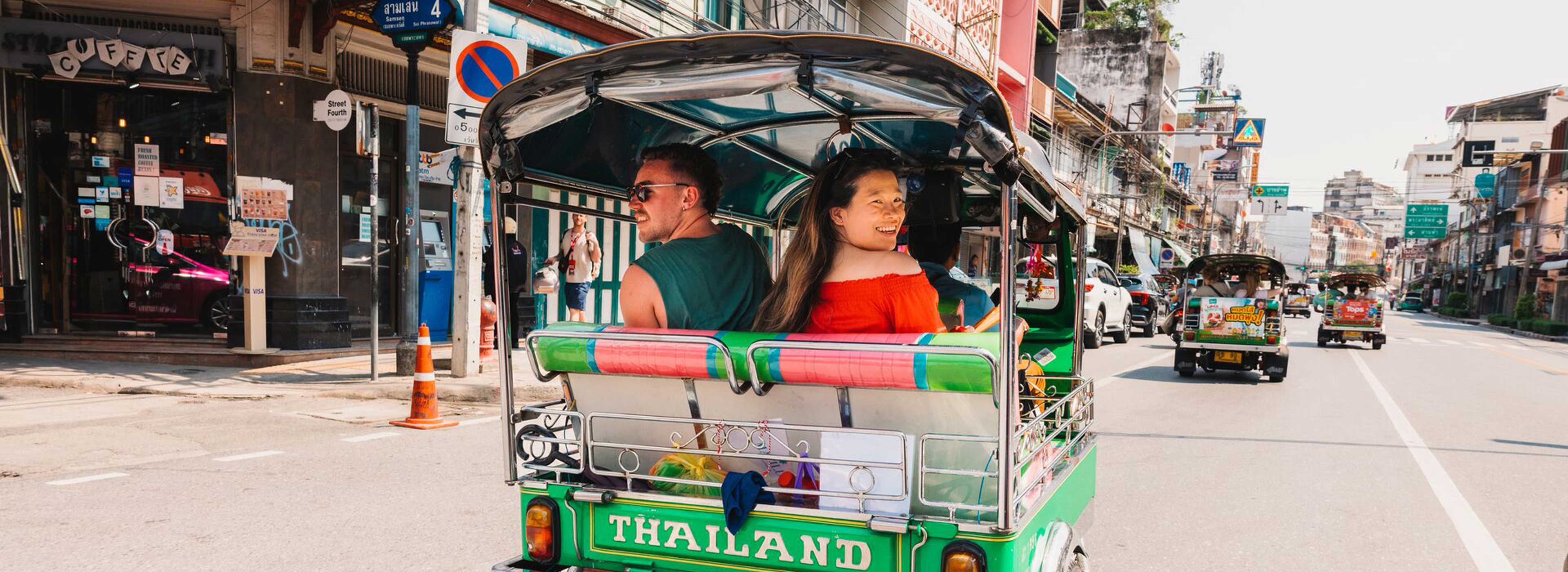 Travellers riding tuk-tuk in Thailand