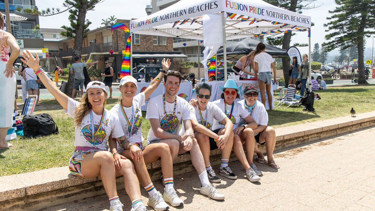Group Of Friends Sat Outside Fusion Pride Tent