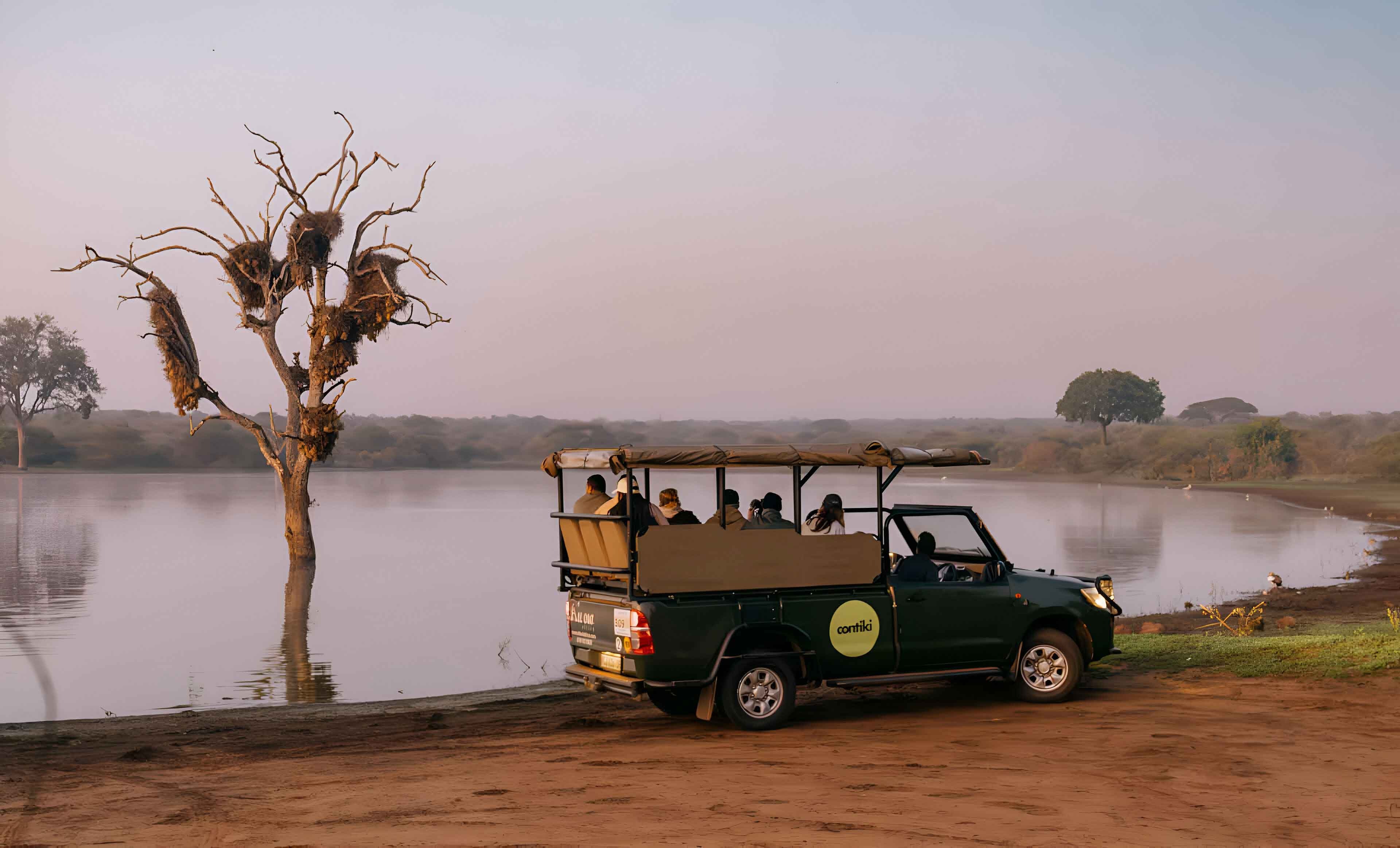 A safari truck driving close to the lake in South Africa.