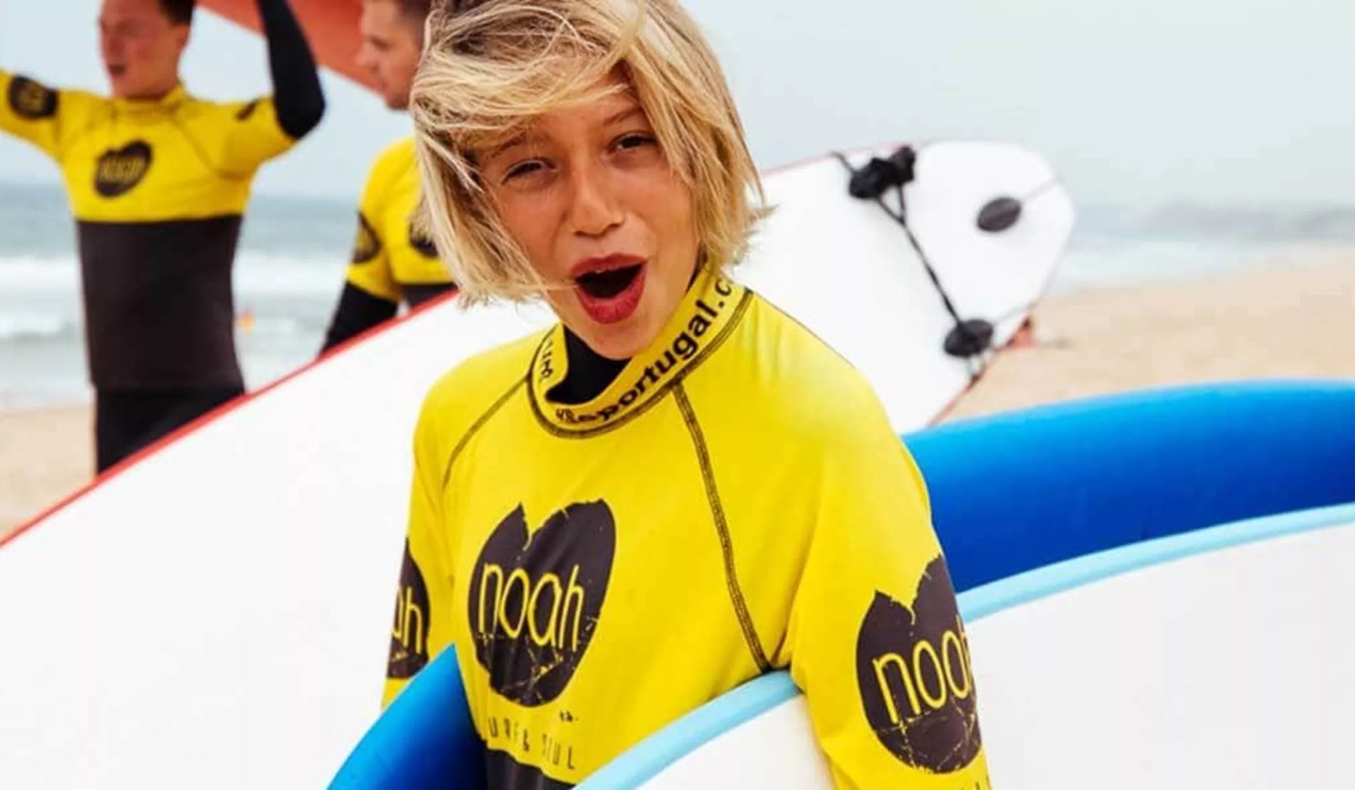 A boy with a funny expression holding a paddleboard
