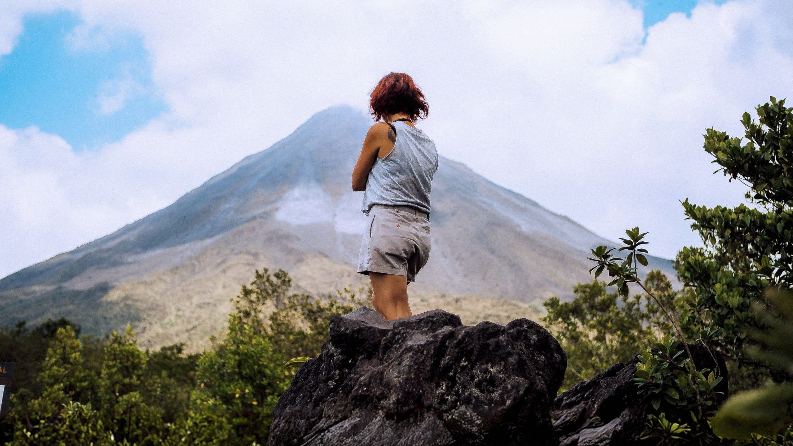 A Contiki traveller pauses to admire the mist-covered Arenal Volcano in Costa Rica on the Tulum to San José Tour