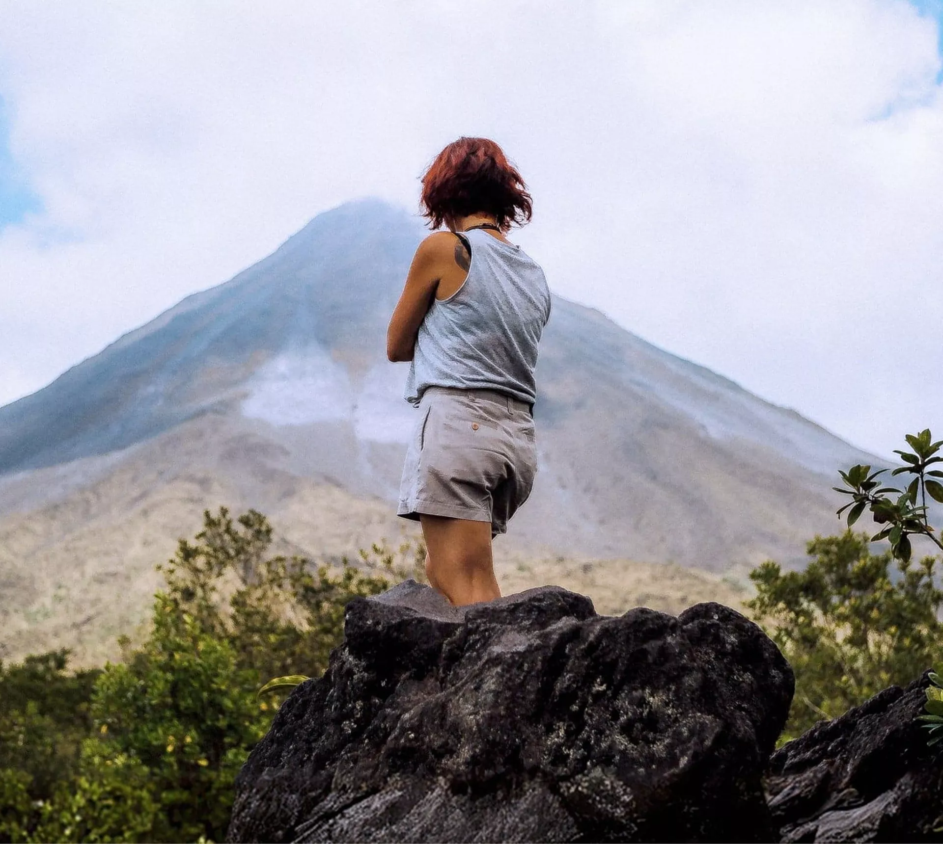A Contiki traveller pauses to admire the mist-covered Arenal Volcano in Costa Rica on the Tulum to San José Tour