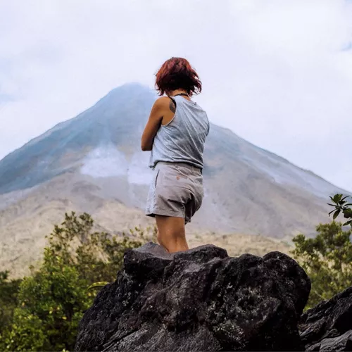 A Contiki traveller pauses to admire the mist-covered Arenal Volcano in Costa Rica on the Tulum to San José Tour