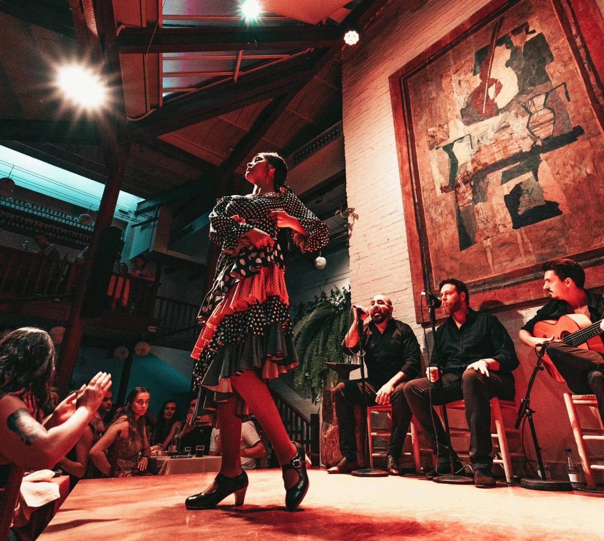 A flamenco dancer performs alongside live musicians as travellers watch an evening show on the Contiki Barcelona to Lisbon Tour