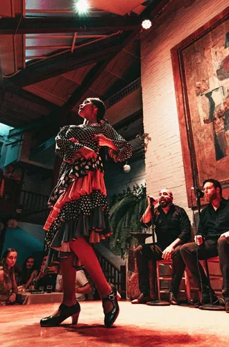 A flamenco dancer performs alongside live musicians as travellers watch an evening show on the Contiki Barcelona to Lisbon Tour
