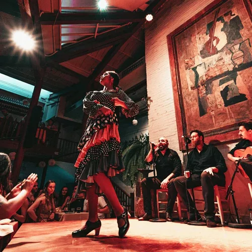 A flamenco dancer performs alongside live musicians as travellers watch an evening show on the Contiki Barcelona to Lisbon Tour