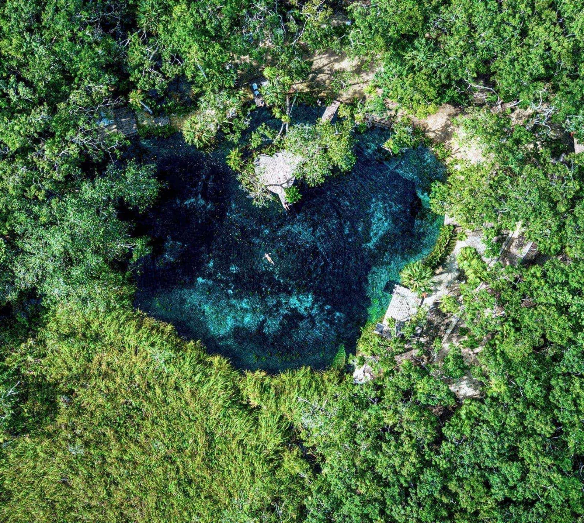 Swim in a secluded jungle cenote, where turquoise freshwater pools offer a refreshing escape on Contiki's Tulum to Antigua Tour