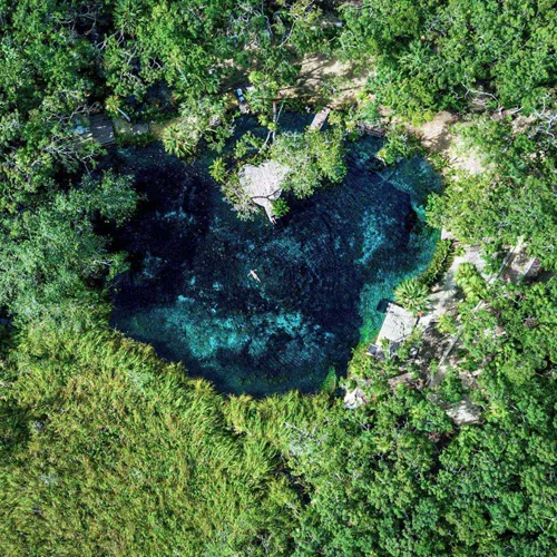 Swim in a secluded jungle cenote, where turquoise freshwater pools offer a refreshing escape on Contiki's Tulum to Antigua Tour