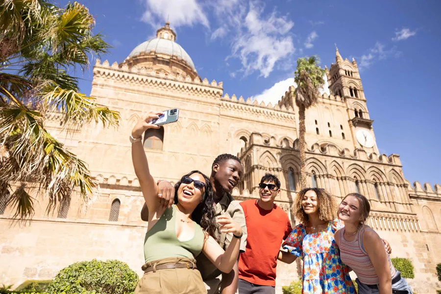 Group Taking Selfie In Front Of Building In Sicily Italy