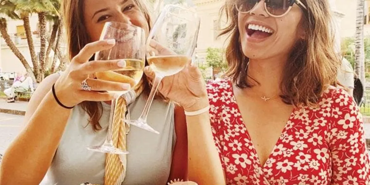 The women smilling and drinking wine