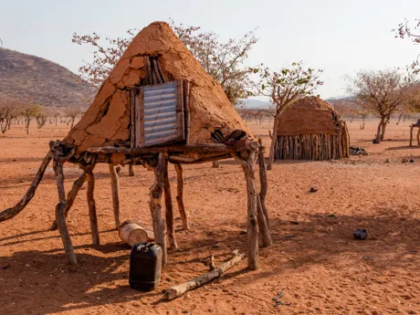 Traditional homes raised off the sandy ground by wooden stakes. Traditional homes of the Herero people of Namibia.