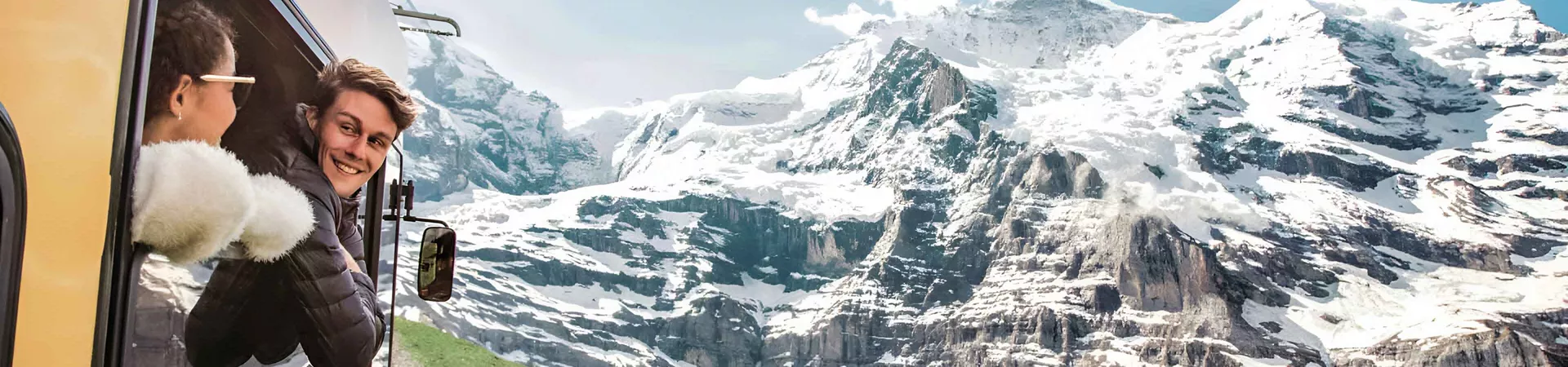 Two Young Happy People Enjoying The Snowy Mountains View From A Train