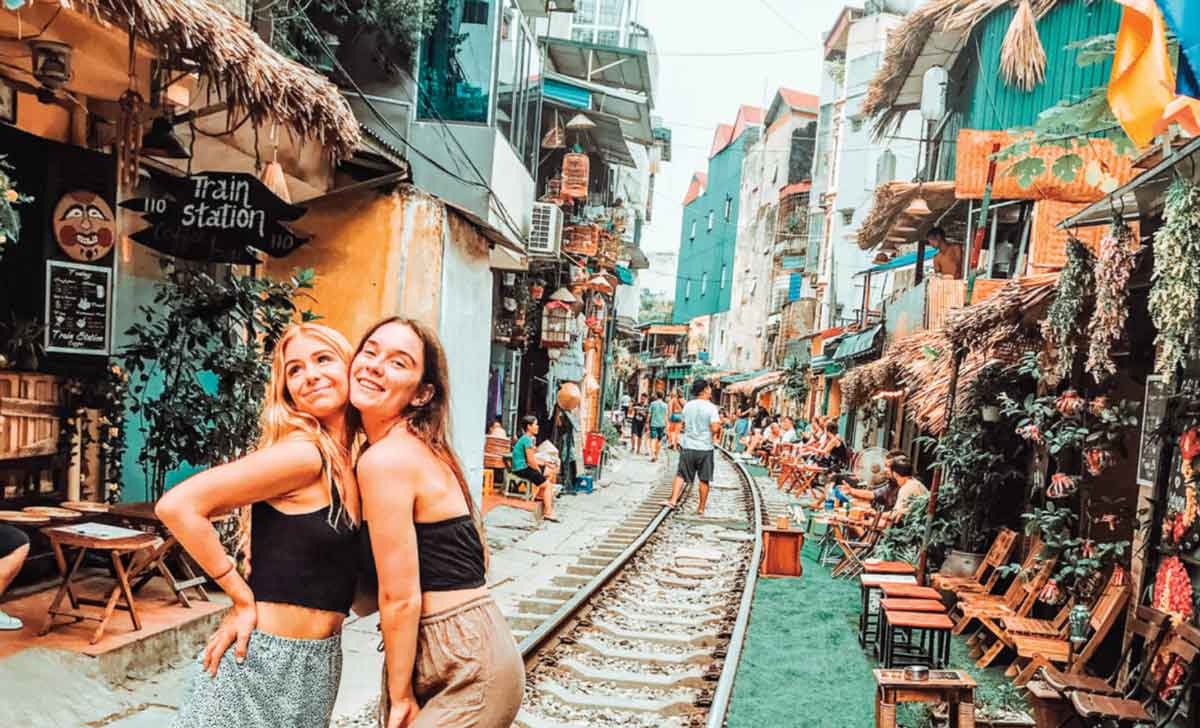 Two Happy Friends Posing For The Poto In A Busy Road