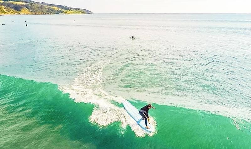 A surfer swimming on a board