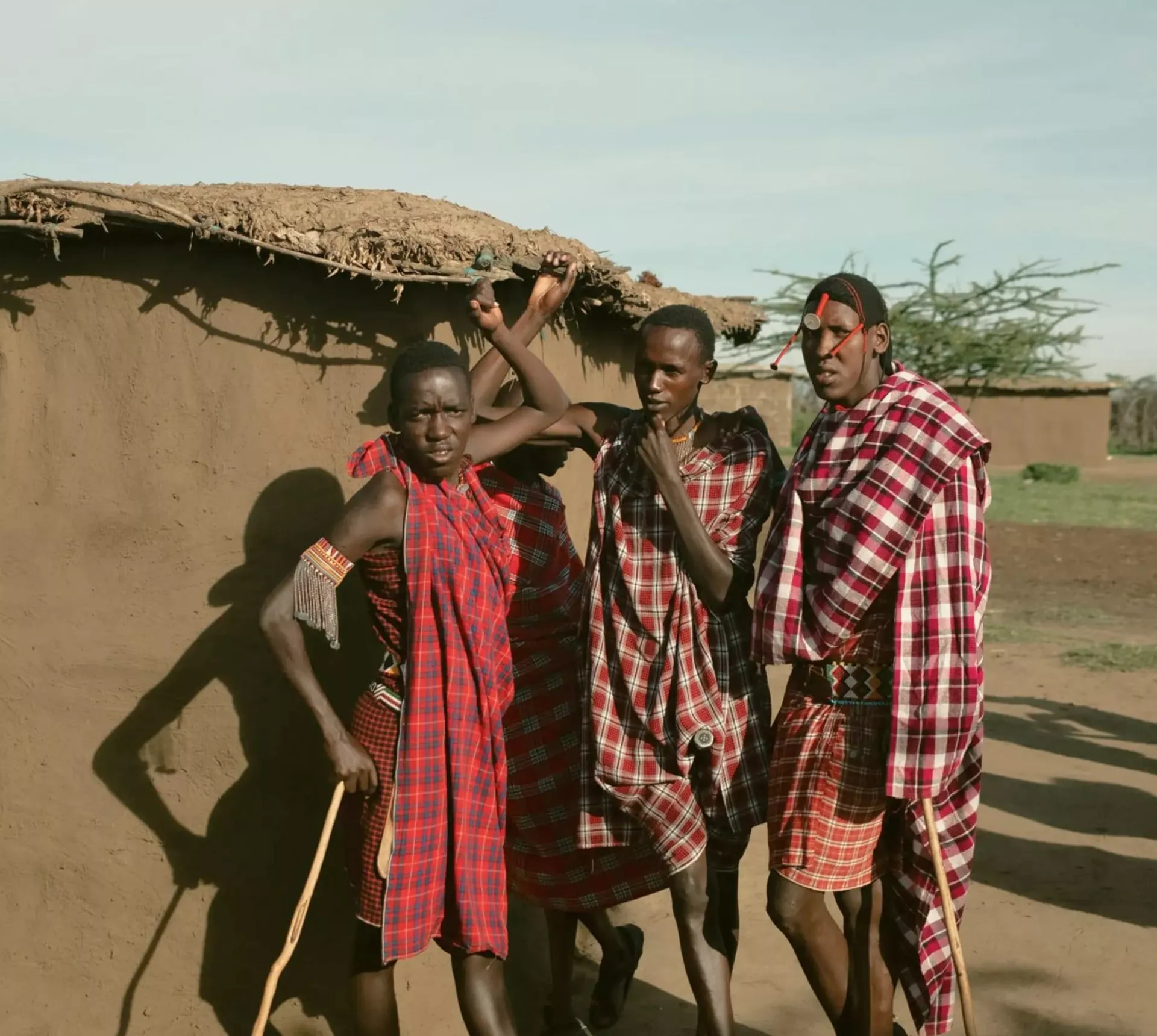 Group meet Maasai community members in a traditional village during Contiki's Kenya: Maasai Mara & Safari Tour