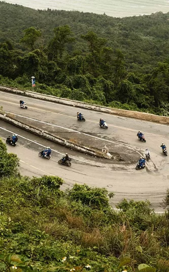 Contiki travellers riding scooters along Vietnam's iconic Hải Vân Pass on Contiki's Ride Vietnam Tour