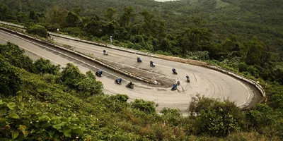 Contiki travellers riding scooters along Vietnam's iconic Hải Vân Pass on Contiki's Ride Vietnam Tour